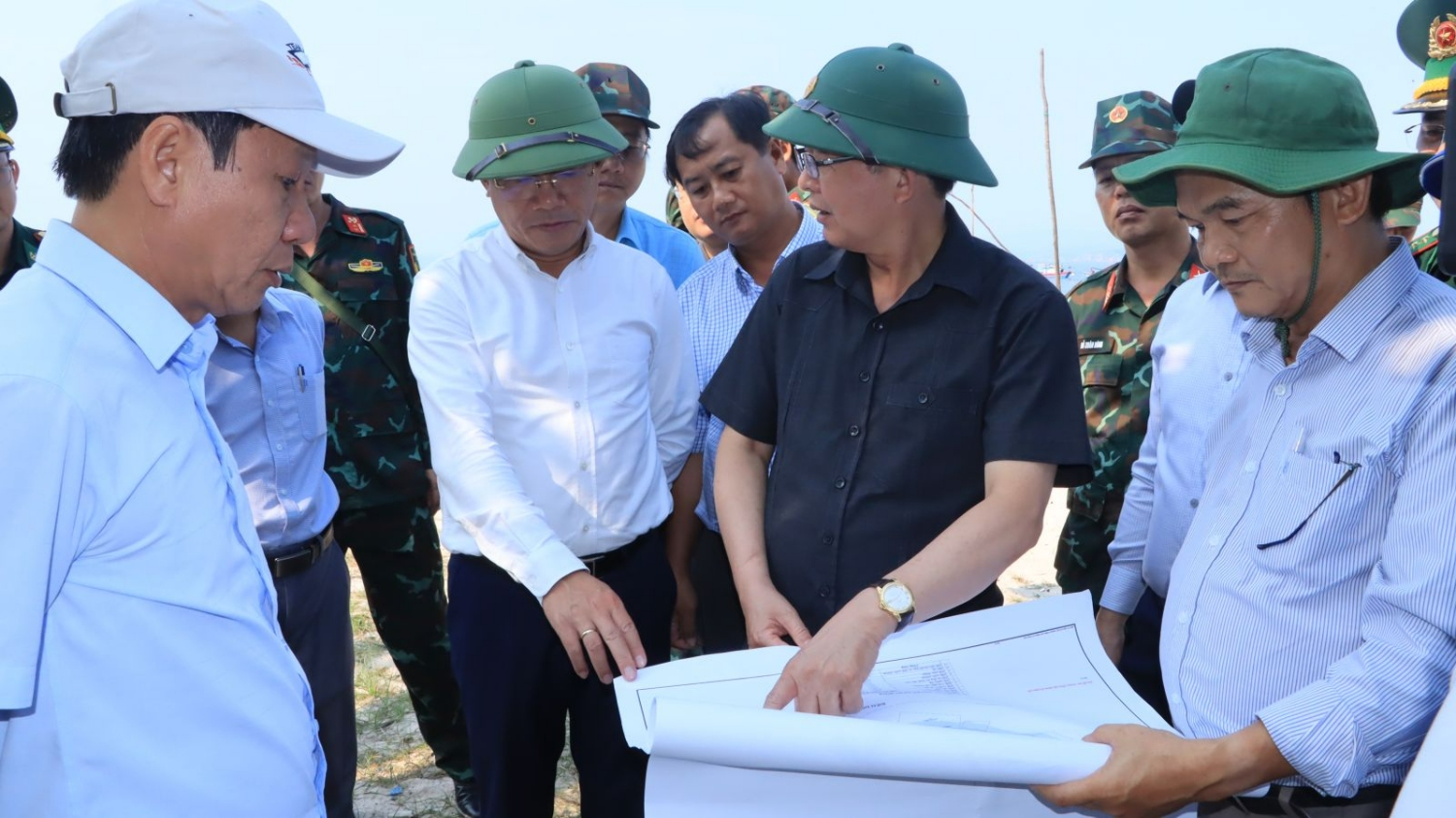 Bí thư Tỉnh ủy Hồ Quốc Dũng (thứ 2, từ phải sang) và Chủ tịch UBND tỉnh Phạm Anh Tuấn (thứ 3, từ phải sang) đối chiếu bản đồ khu vực bãi biển nhà văn hóa thôn Đông nằm trong quy hoạch xã Nhơn Châu